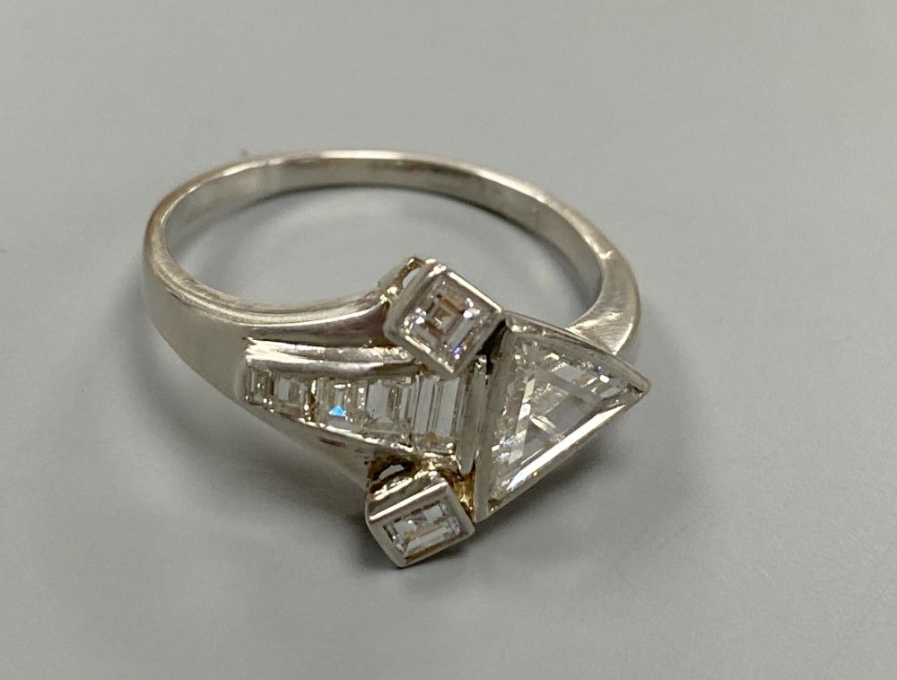 An unusual white metal (stamped Plat), triangular, square and graduated baguette cut diamond cluster set dress ring,